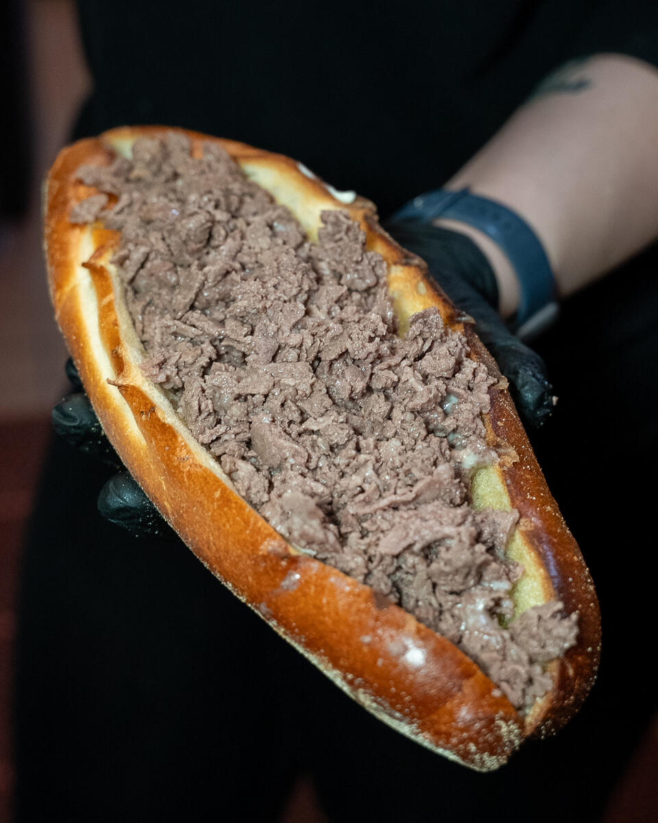 Legendary cheesesteak held open
